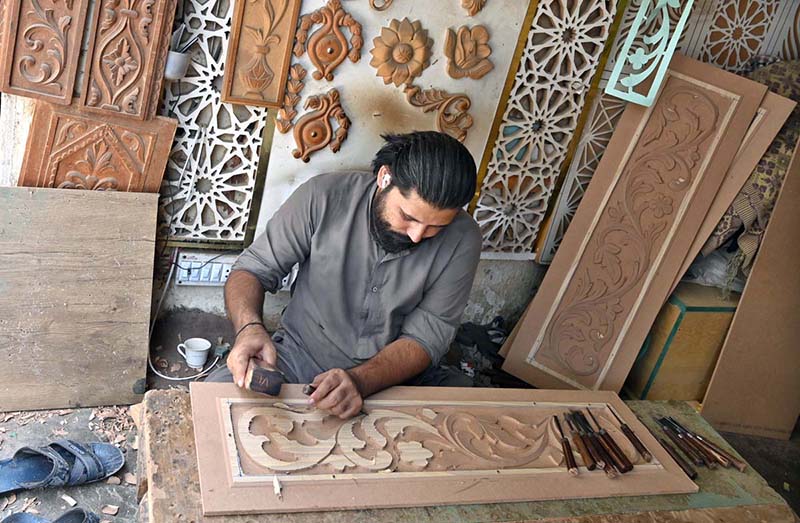 A worker is busy in carving different designs on sheet in his workshop at Saidpur Road