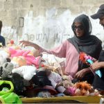 A couple purchasing used toys from a roadside vendor