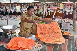 A vendor displaying traditional food item (Katlama) to attract the customers at his shop.