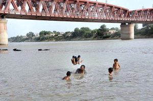 Youngster jumping and bathing in Phuleli Canal to get relief from hot weather in the city.