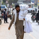 A vendor selling men’s vests while shuttling on Lehtrar Road