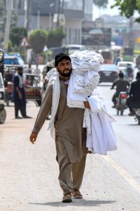 A vendor selling men’s vests while shuttling on Lehtrar Road