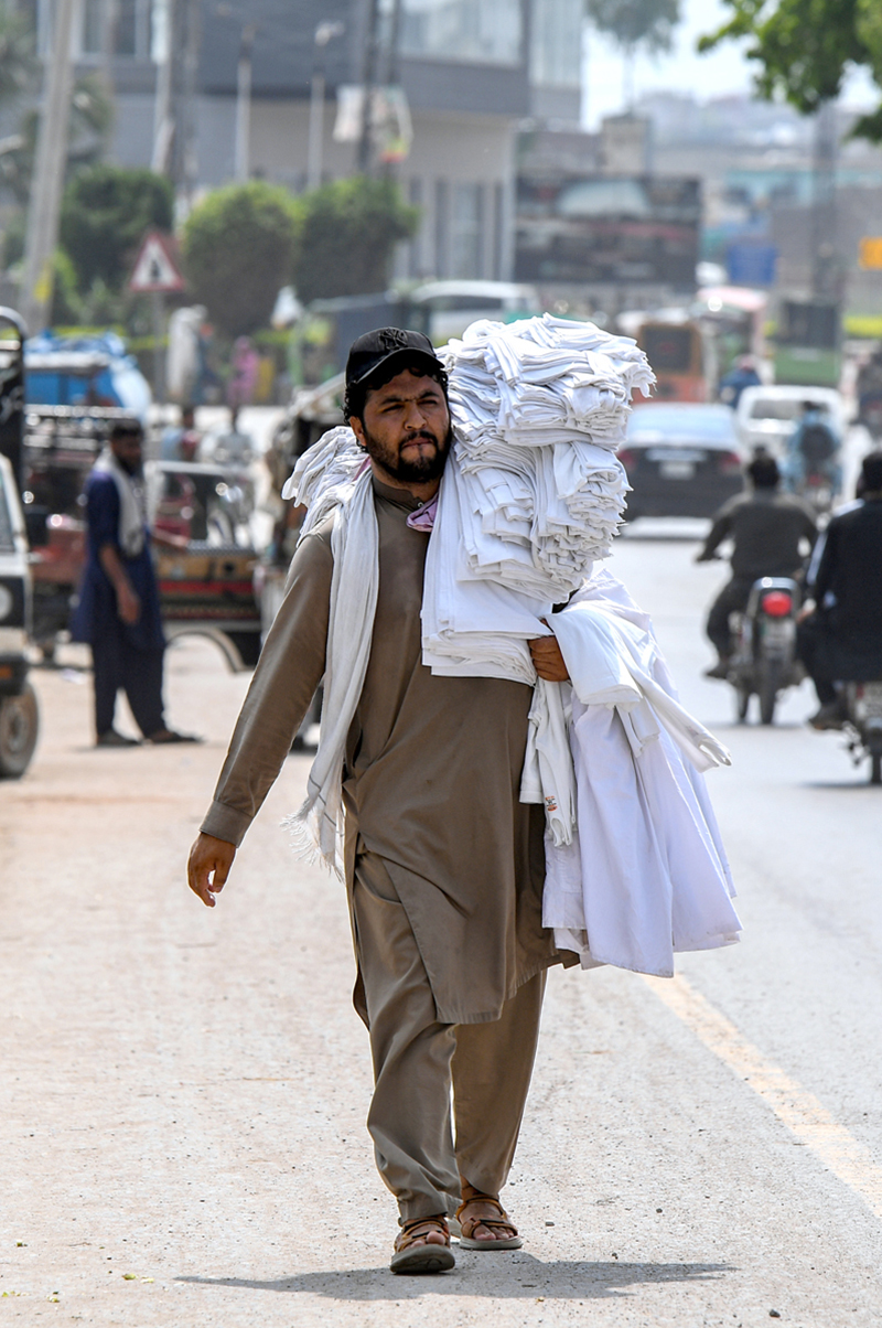 A vendor selling men’s vests while shuttling on Lehtrar Road
