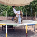 Children enjoying a fun-filled time as they jump and play on a trampoline set up on the roadside