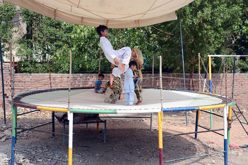 Children enjoying a fun-filled time as they jump and play on a trampoline set up on the roadside