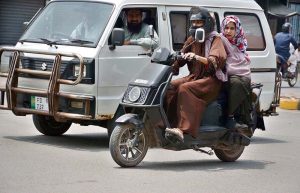 Women ride a scooty towards their destination at D-Ground during routine traffic movement in the city.