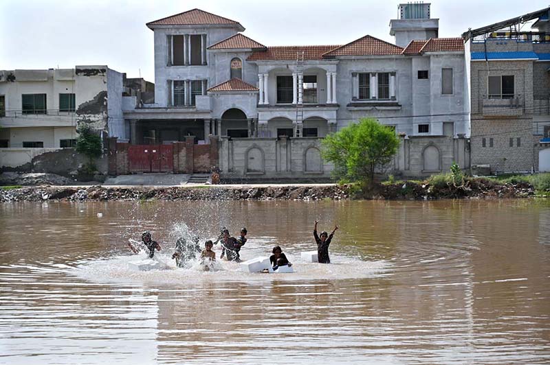 Children are playing in stagnant rainwater accumulated at Qasim Park