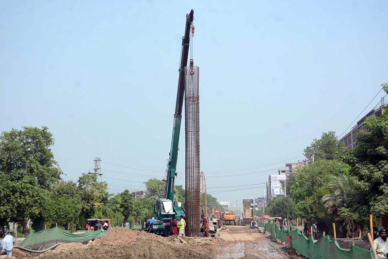 Labourers are busy construction work on Jaranwala Road with the help of heavy machineries during development work of Metro Project