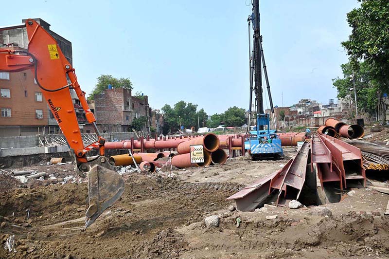 Heavy machinery and construction equipment are deployed at the site of an under-construction parking plaza at Mochi Ground