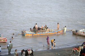 A large number of people are enjoying themselves at Al-Manzar Picnic Point on the Indus River during the hot weather in the city.