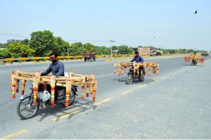 Motorcyclists are on their way to deliver handcrafted wooden beds, known locally as "charpai" to local markets on the outskirts of the city.