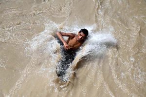 Youngsters jumping and bathing in Dadu Canal to get some relief from scorching hot weather in the city.
