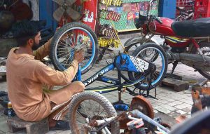 A mechanic is busy repairing bicycle at his workshop