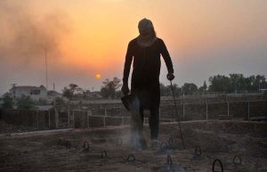 A worker adds fuel to the firing chambers of a traditional brick kiln to maintain the temperature needed for baking raw bricks in the city.
