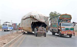 An out of order overloaded tractor-trolley heavily loaded with husk on Muzaffargarh Road, causing traffic disruption as vehicles cautiously made their way around the stranded vehicle.