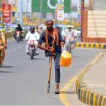 A physically challenged man sells edible snacks while making his way along Kalma Chowk Road, earning his livelihood despite physical disability, in the city