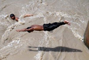 Youngsters jumping and bathing in Dadu Canal to get some relief from scorching hot weather in the city.