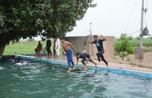 Youngsters jumping and bath in swimming pool to get relief from hot weather in the city.