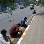 Labourers are busy painting the roadside footpath at Club Chowk as part of a civic beautification drive