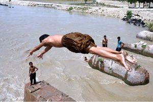 Youngsters jumping and bathing in Dadu Canal to get some relief from scorching hot weather in the city.