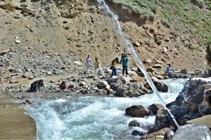 Tourists enjoy the crystal-clear, glacier-fed waters along the scenic riverside at Batakundi in Kaghan Valley.
