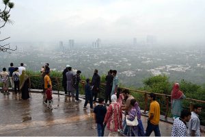 Visitors gather at the Daman-e-Koh viewpoint atop the Margalla Hills to enjoy the spectacular monsoon view of Federal Capital shrouded in rain clouds and mist