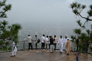 Visitors gather at the Daman-e-Koh viewpoint atop the Margalla Hills to enjoy the spectacular monsoon view of Federal Capital shrouded in rain clouds and mist
