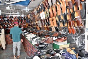Customers shop for footwear at a shoe store in the main bazaar during routine business activity.