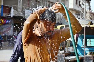 A labourer is bathing to get some relief from the hot weather in the city.