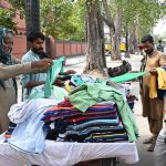 People buy old clothes from a hand-card at Empress Road