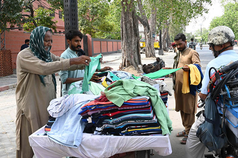 People buy old clothes from a hand-card at Empress Road