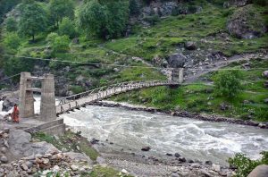 Tourists enjoy the crystal-clear, glacier-fed waters along the scenic riverside at Batakundi in Kaghan Valley.