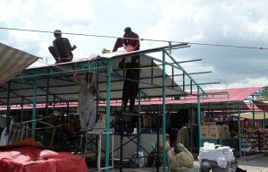 Workers install shade structures over newly rebuilt stalls as reconstruction work continues at the H-9 Weekly Bazaar following the devastating fire that destroyed the market.