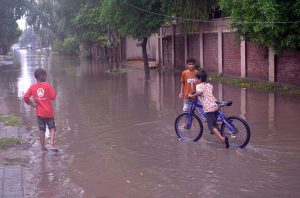 WASA officials work to drain rainwater accumulated at Khayam Chowk following heavy rainfall in the city.