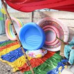 A vendor sells plastic swimming pools at his roadside setup