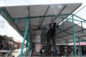 Workers install shade structures over newly rebuilt stalls as reconstruction work continues at the H-9 Weekly Bazaar following the devastating fire that destroyed the market.