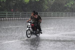 A motorcyclist makes his way through heavy rain in the Provincial Capital