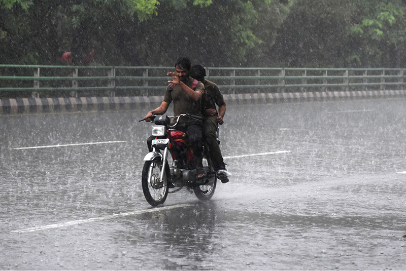 A motorcyclist makes his way through heavy rain in the Provincial Capital
