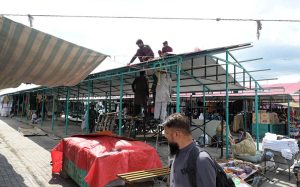 Workers install shade structures over newly rebuilt stalls as reconstruction work continues at the H-9 Weekly Bazaar following the devastating fire that destroyed the market.