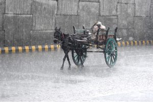 A motorcyclist makes his way through heavy rain in the Provincial Capital