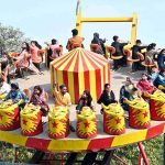 Families enjoy swings at Gulshan-e-Iqbal Park during a recreational outing in the city