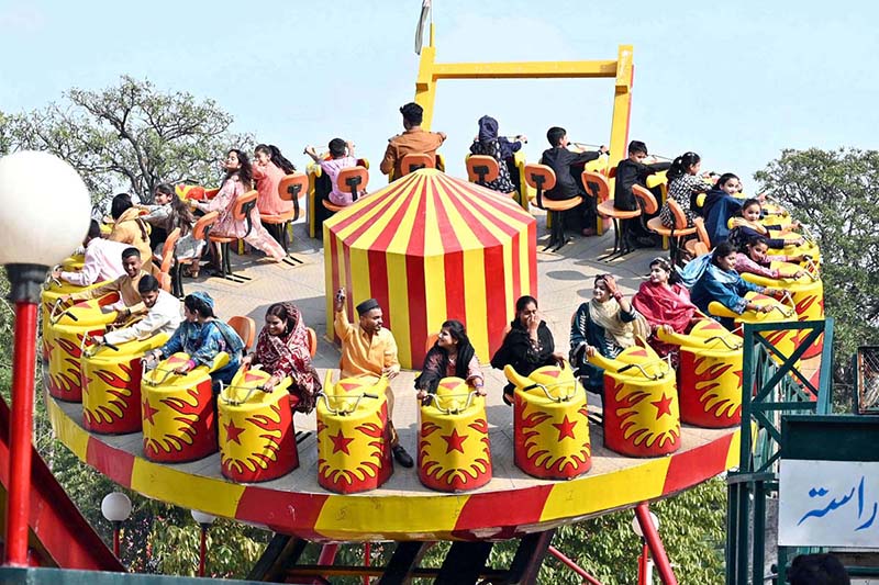 Families enjoy swings at Gulshan-e-Iqbal Park during a recreational outing in the city