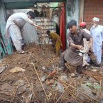 People clear debris after the roof of a shop collapsed following heavy monsoon rains in the provincial capital
