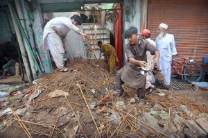 People clear debris after the roof of a shop collapsed following heavy monsoon rains in the provincial capital