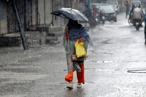 A motorcyclist makes his way through heavy rain in the Provincial Capital