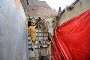 People clear debris after the roof of a shop collapsed following heavy monsoon rains in the provincial capital