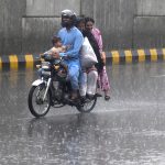 A motorcyclist along with his family members makes his way through heavy rain in the Provincial Capital