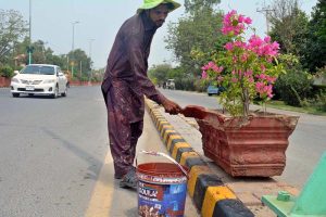 Parks and Horticulture Authority (PHA) worker paint the flower pot at Jail road.