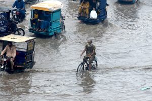 A motorcyclist along with his family members makes his way through heavy rain in the Provincial Capital