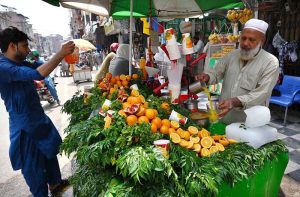 Vendor selling and preparing fresh orange and pomegranate juice during hot weather in the Provincial Capital at Qissa Khawani.